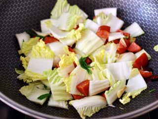7、火腿炖白菜,先加入大白菜帮,大火继续翻炒片刻。