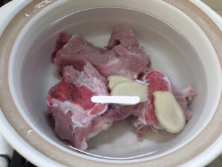 3、筒骨莲藕汤,准备一锅冷水放入筒骨和姜片，开大火