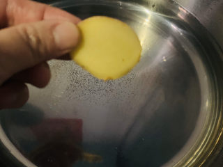 1、冬笋排骨汤,把姜片放入清水中；