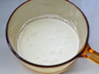 6、奶油蘑菇浓汤,将牛奶和淡奶油倒入锅中小火煮开