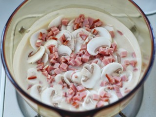 9、奶油蘑菇浓汤,放入火腿丁和口蘑搅拌均匀煮开