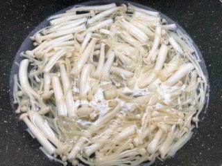4、虾仁菌菇汤,锅里放入适量水烧开，把金针菇和海鲜菇放入焯1分钟捞出，沥干水待用。