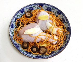 5、虫草花蒸鸡腿,底下先放些葱段,摆上鸡腿,放上虫草花和泡发好的香菇、姜片。