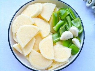 2、好吃到哭的茄汁土豆片,土豆去皮切片，泡水10分钟清洗掉淀粉。青椒切小块，大蒜拍扁。