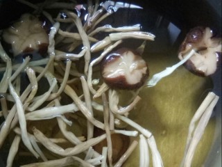 1、鲜美巴沙鱼汤,汤锅放入香菇和黄花菜加水炖。