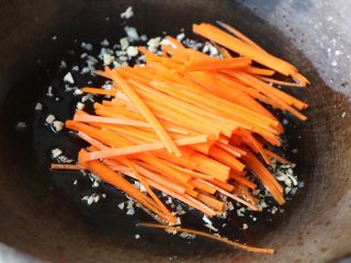 8、蒜苔炒腊肠,放入胡萝卜丝翻炒均匀；