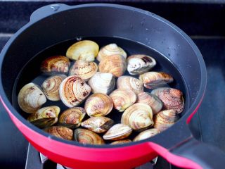 3、金汤文蛤时蔬酸辣汤,锅中倒入适量的清水,文蛤提前浸泡出泥沙洗净放入锅中。