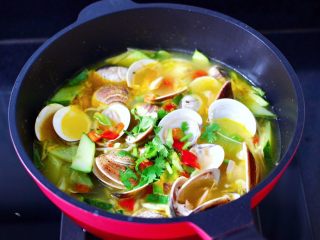 14、金汤文蛤时蔬酸辣汤,大火煮沸后撒上香菜段和红椒丁就可以关火了。