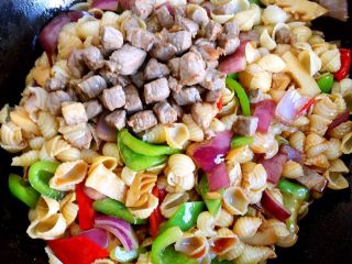 10、蚝油双椒牛肉贝壳面＋#面条变身计划#,放入炒过的牛肉丁，翻炒均匀，尝味即可，喜欢吃辣的朋友也可单点辣油，味道更香哦。