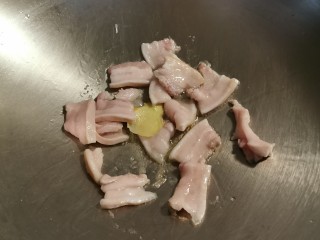 6、辣白菜豆腐汤,起油锅 油热后放入姜片 炒出香味 放入五花肉片翻炒