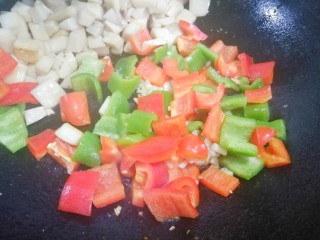 4、超下饭的双椒杏鲍菇,杏鲍菇铲到一边,锅中加适量油,下入姜蒜爆香,加青红椒大火翻炒片刻。