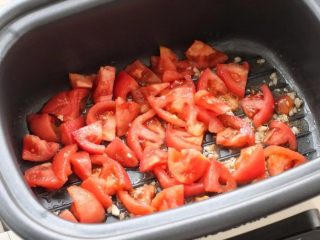 5、番茄肥牛,锅中倒适量食用油烧热，放入蒜末炒出香味，再把番茄放进去炒出汤汁。