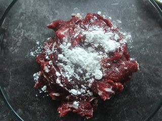 3、麻辣滑嫩的水煮牛肉,倒入一汤匙油、一小匙盐和一小匙淀粉抓匀备用。