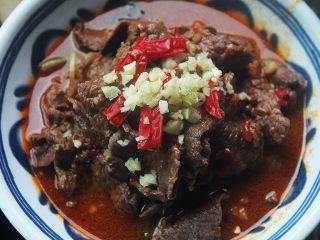 11、麻辣滑嫩的水煮牛肉,把汤倒入碗中，没过牛肉一半就行，在牛肉片上放上几个辣椒，适量蒜末；