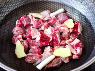 4、牛腩炖萝卜,锅中倒入适量的清水，放入4片姜1根小葱。