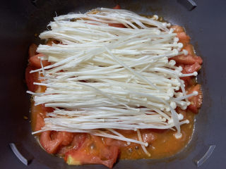 12、金针菇豆腐汤,铺上沥干水分的金针菇。