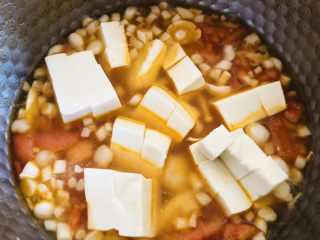 9、白玉菇豆腐汤,水煮开后倒入豆腐继续煮开。