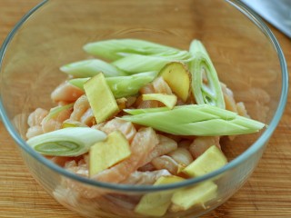 4、香酥炸鸡柳,将鸡肉条和葱姜一起放入容器中