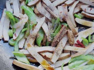 6、青椒炒豆干,再倒入适量生抽，盐，鸡精，五香粉，炒几下就可以了