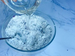 8、甜蜜紫薯球,分次倒入清水，一边放一边搅拌！让糯米粉吸收好水分！