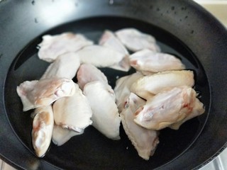 1、孜然烤鸡翅#烤箱版#,首先将鸡翅洗干净，再焯水，冷水入锅，大火烧开，1分钟即可捞出。