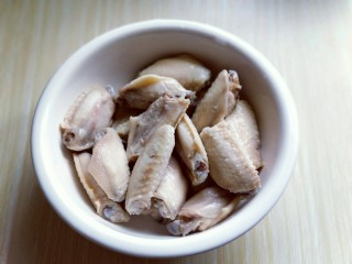 2、孜然烤鸡翅#烤箱版#,捞出后立即过冷水，反复冲洗，将鸡翅的杂质冲洗干净，装入大口器具中。
