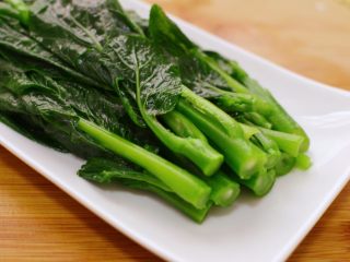 9、白灼菜心,关火。用筷子夹出来，摆入盘中。