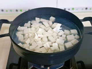 5、海带豆腐汤,锅中加入水烧开,下豆腐块焯水,大火煮1分钟捞出淋干水分。