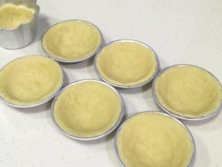 12、港式蛋挞,放入蛋挞模具中，用大拇指按压至完全贴合模具的薄片状。