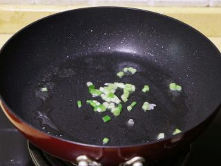 3、酱烧杏鲍菇,香葱取葱白部分切碎,然后放入油锅中爆一下