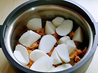 10、白萝卜汽锅鸡,把切好的白萝卜摆放在鸡块上面。