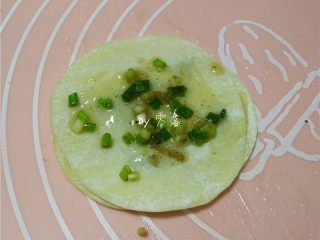9、快手葱油饼,在饺子皮上刷上葱油;