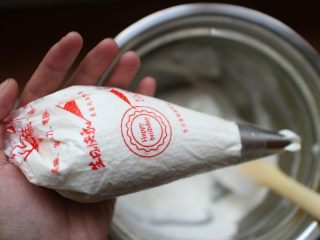 12、芒果盒子蛋糕,将打发好的淡奶油装进裱花袋。我的裱花袋装了花嘴，没有的同学可以不用装裱花嘴！