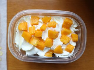 17、芒果盒子蛋糕,然后在挤一层奶油，在撒上一层芒果粒即可。做好后用盖子盖好，送进冰箱冷藏一会在吃口感更佳！