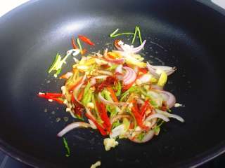 6、爆炒蛏子,接着加入一大勺豆瓣酱翻炒均匀，适量加一点水。