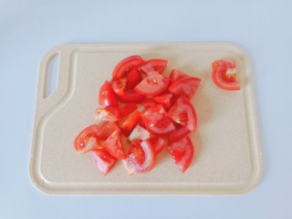 2、豆皮金针菇卷,番茄对半切开再切小片。