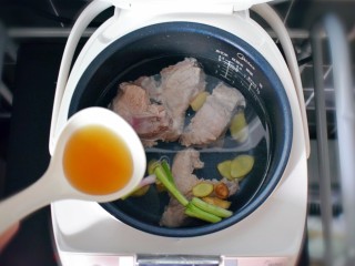 6、玉米胡萝卜山药排骨汤,将排骨放入电饭煲内胆,并放入适量的清水,加入葱段、姜片,适量的料酒。按下粥/汤键,我家的电饭煲煲汤是需要2小时。