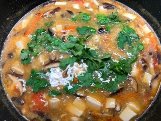 5、杂烩酸辣汤,加入适量鸡精调匀，再放入香菜即可出锅。