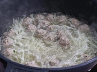 7、萝卜丝汤,下入萝卜丝和粉丝，搅拌均匀煮沸后再煮约一分钟。