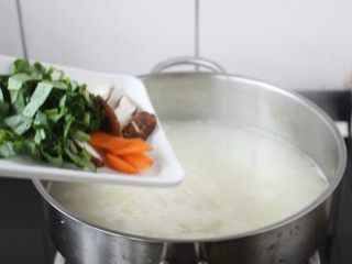 6、童子鸡鸡汤面,放入青菜叶、香菇片、胡萝卜片。