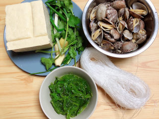 1、花蛤豆腐汤,准备好食材。花蛤、裙带菜、豆腐、粉丝、葱姜蒜、香菜。