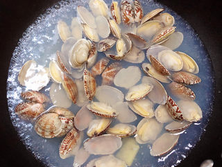 2、花蛤豆腐汤,锅中烧热水，加入料酒、生姜片，放入花蛤煮一下，祛除腥味。