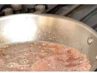 5、牛排,加入一半牛油.黑胡椒碎.翻炒一下.加入洋葱碎.大蒜一起炒香。