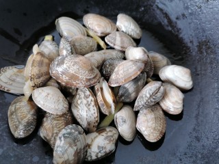 8、丝瓜花蛤汤,将花蛤放入锅内翻炒