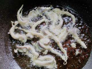 5、酥炸蘑菇,小奶锅适量油，烧至五六成热，用筷子一个个夹进锅里炸。不要轻易去动它，等定型再翻动，怕脱糊了