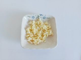 3、金针菇豆腐汤,蒜放在案板拍一下，剥皮再剁成泥。