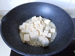 5、金针菇豆腐汤,热锅凉油爆香蒜泥，下豆腐块翻炒一下。