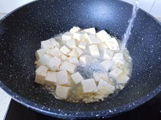 6、金针菇豆腐汤,加入适量的水开大火将豆腐烧开。
