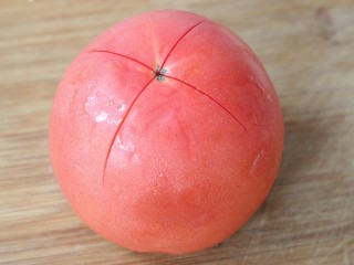 2、西红柿鸡蛋汤面,首先将西红柿清洗干净，用刀在上面划成十花～