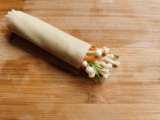 6、豆皮金针菇卷,把豆皮卷起来，卷的时候一定要卷紧，防止烹饪时散掉。